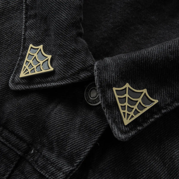 "Cobweb" black enameled gold metal clutch-back pin set to fit on collar points. Shown on black denim jacket 