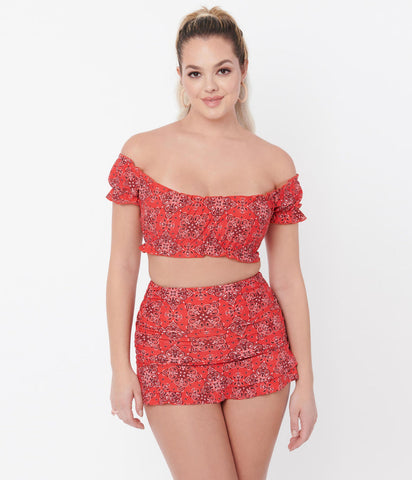 A model wearing a red off the shoulder style swim top and bottom in a red western bandana style