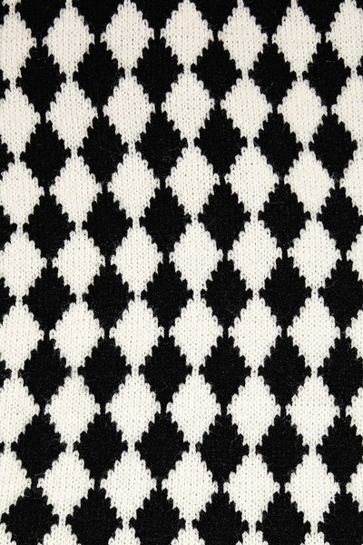 A knit black and creamy white scarf in a Harlequin pattern. Shown up close to display knit texture 