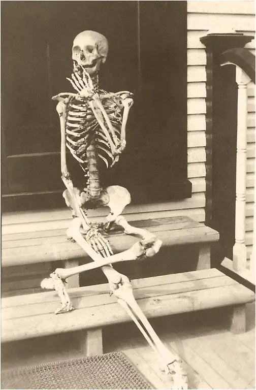 Sepia vintage photo of a skeleton posed and smoking a cigarette 
