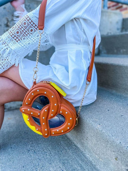 A model wearing the pretzel purse with its removable gold chain strap 