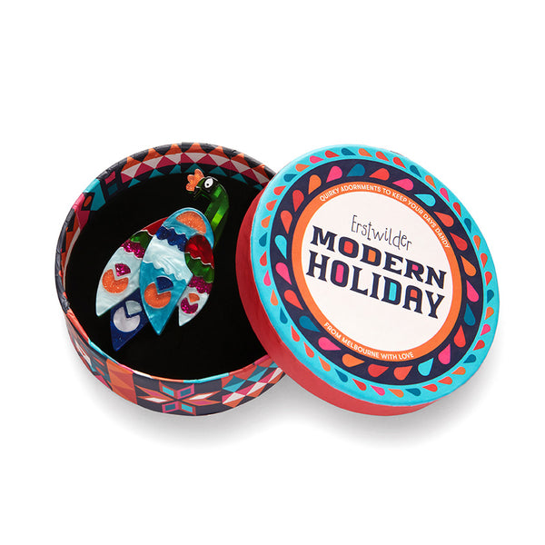 Modern Holiday Collection "Good Tidings Peacock" layered resin brooch, shown in illustrated round box packaging