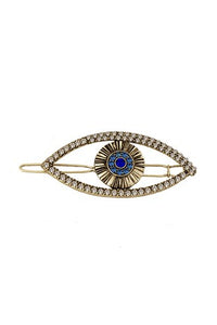 Clear jeweled gold metal evil eye-shaped barrette clip with a blue jeweled iris.