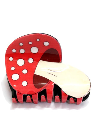 A plastic claw style hair clip in the shape of a single red and white toadstool mushroom