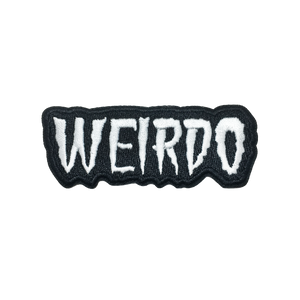 An embroidered patch of the word “WEIRDO” in white capital letters on a black background