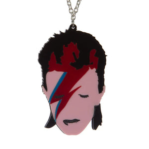 An 18” silver metal alloy chain necklace featuring a laser-cut and hand assembled layered acrylic pendant featuring the stylized face of David Bowie’s iconic 1973 persona Aladdin Sane