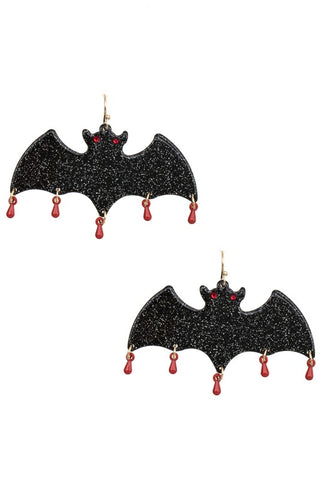 Acrylic dangle earrings in the shape of black glittery bats with red rhinestone eyes and beaded drops of blood attached to the bottom of each wing fold