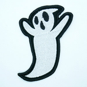 A black and white patch of a classic cartoon ghost with two eyes and an open mouth. Its arms are raised
