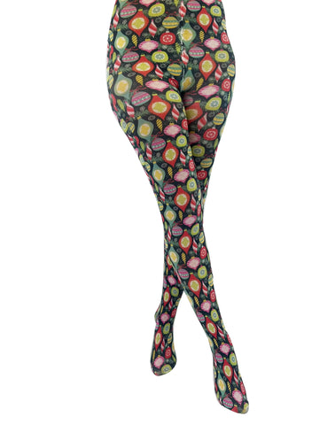 vibrantly colored novelty tights featuring assorted vintage style Christmas ornaments, snowflakes, and evergreen branches against a black background, shown on model