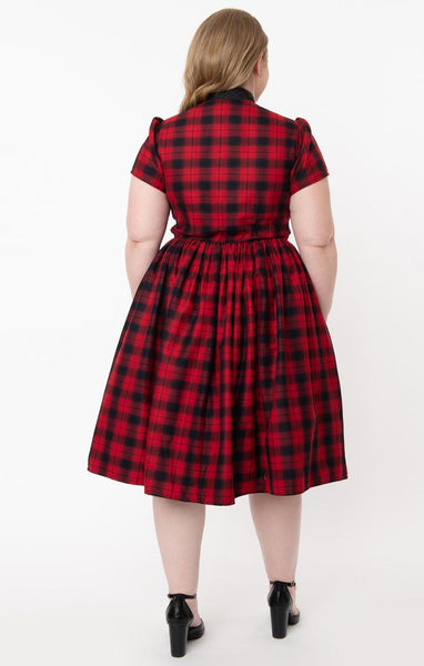 Cora Dress in rich red & black plaid features front button closure, fit & flare silhouette with gathered skirt in a just below the knee length, short puff shoulder sleeves, side seam pockets, and a black tie-closure collar. Shown back view on model.