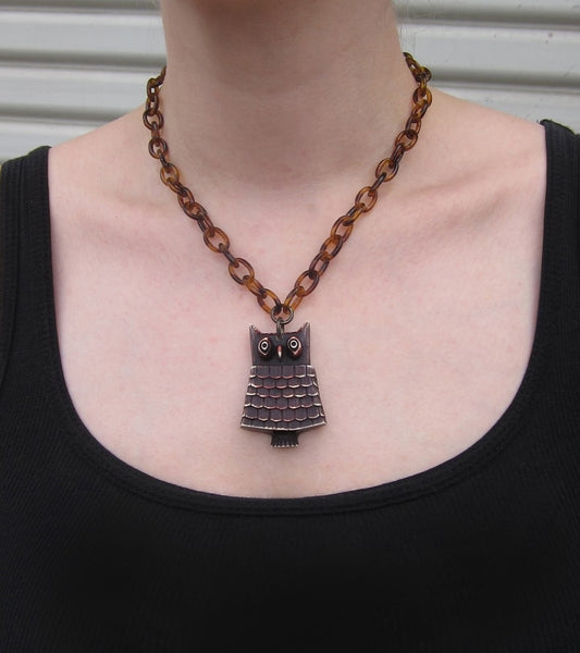 distressed brown & ivory Retrolite 2 1/8" stylized owl pendant on 17" tortoiseshell plastic link chain, shown on model