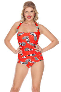 50's style one piece swimsuit in bright orange background allover black & white stripe beach umbrella print ruched body, skirted front and halter neck ties, shown on model