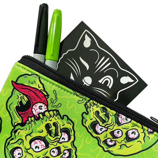 A neon green neoprene zip pouch with a neon green and pink drippy skull and eyeball pattern. Art by Nik Scarlett. A shot showing the detail of the neoprene and the pattern