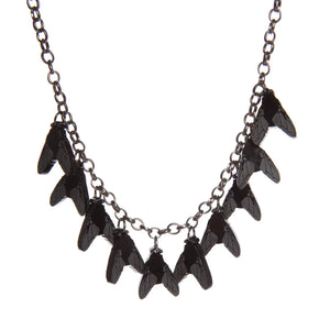 A gunmetal colored chain link necklace with ten acrylic laser-cut charms in the shape of flies with matte etched wing detailing 