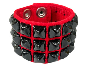 thick classic red canvas wristband with 3 rows of black metal pyramid studs and a double heavy duty snap closure