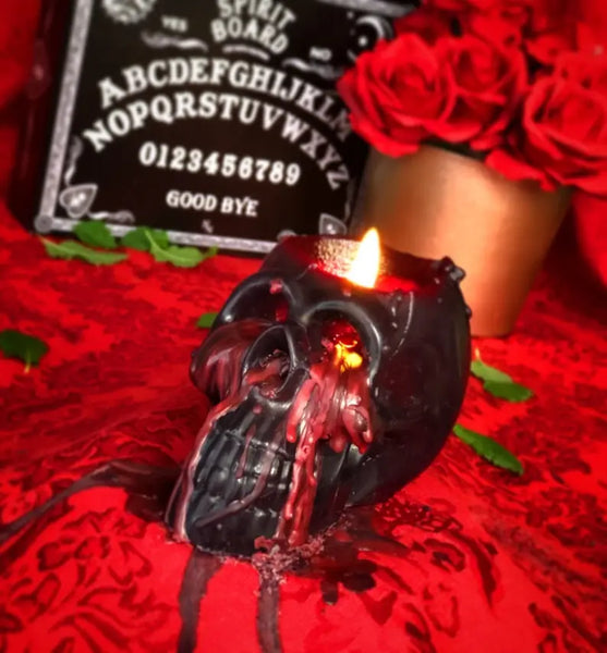 4” tall black skull-shaped candle that “bleeds” red wax when lit. Shown lit with red wax dripping down its side