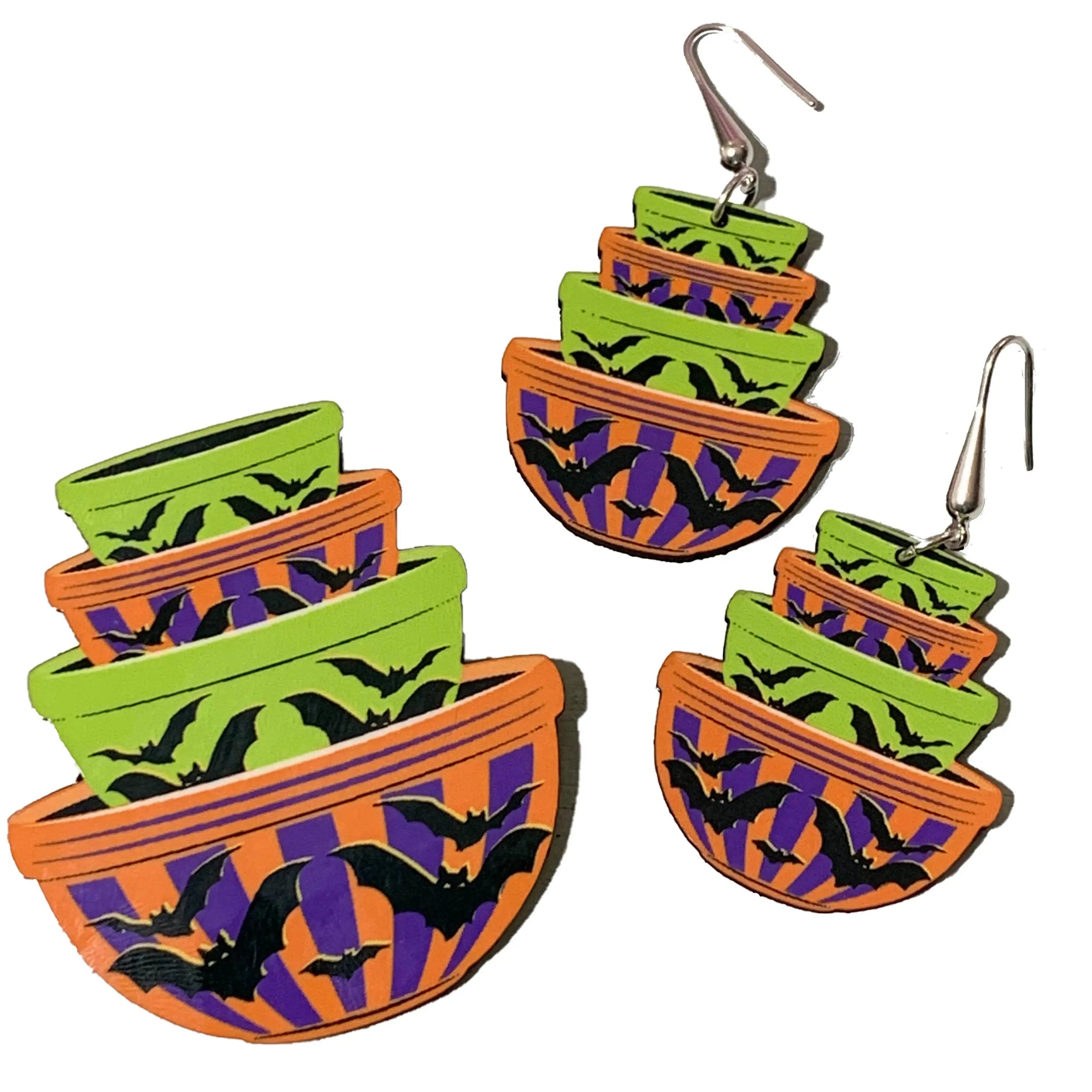 A set of dangle earrings and a brooch in the shape of a stack of green, purple, and orange mixing bowls in the style of vintage Pyrex kitchenware. Each piece is a stack of 4 striped bowls and has small black bats on each 