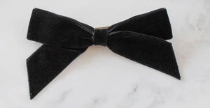 A hair bow made of 1” black velvet ribbon 