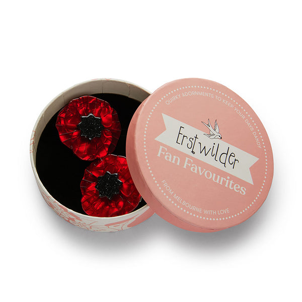 set of two red with black glitter center poppy bloom layered resin hair clips, shown in illustrated round box packaging