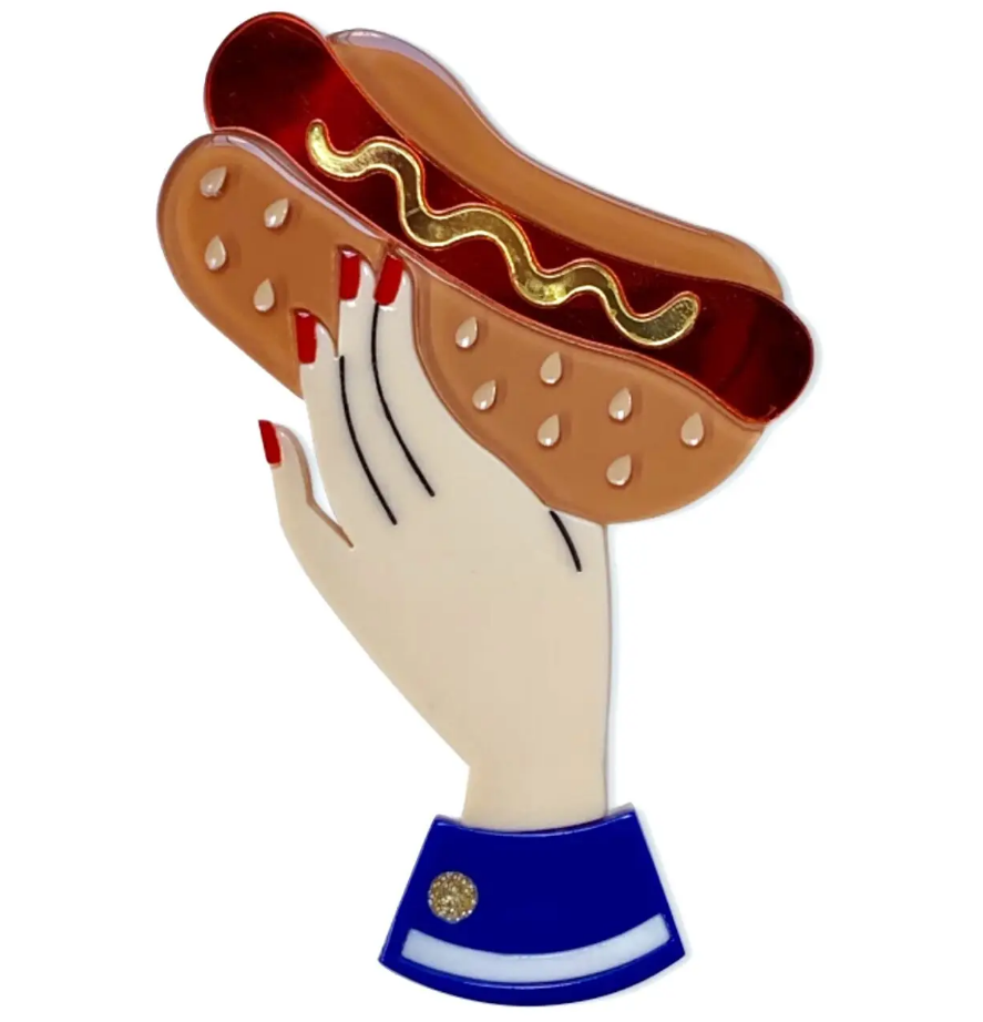 "Bessie's Special" shiny mirror finish mustard-topped hotdog held in a red fingernailed lady hand layered laser cut resin brooch