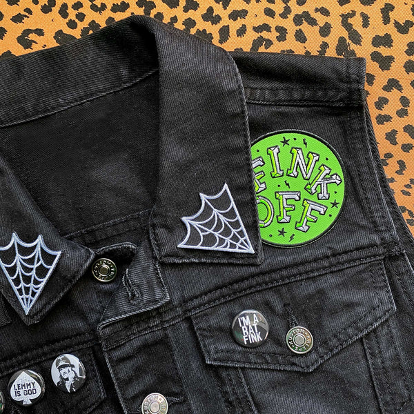 set of two black and white embroidered pointed spiderwebs (in opposing design) as seen on the collar of a black denim vest