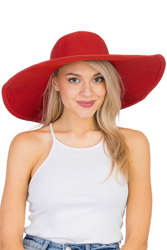 Model wearing broad brimmed sun hat in bright red