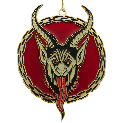 face of Krampus, the Christmas Devil, depicted on a circular enameled gold metal ornament