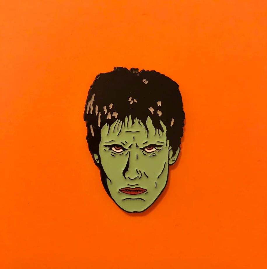 glow-in-the-dark green enameld black metal face of  The Cramps' frontman Lux Interior clutch back fastener pin