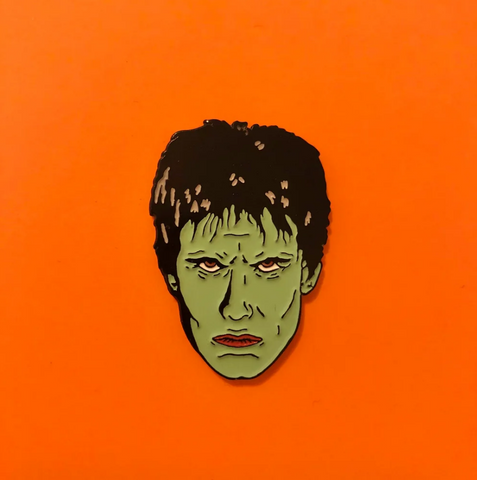 glow-in-the-dark green enameld black metal face of  The Cramps' frontman Lux Interior clutch back fastener pin