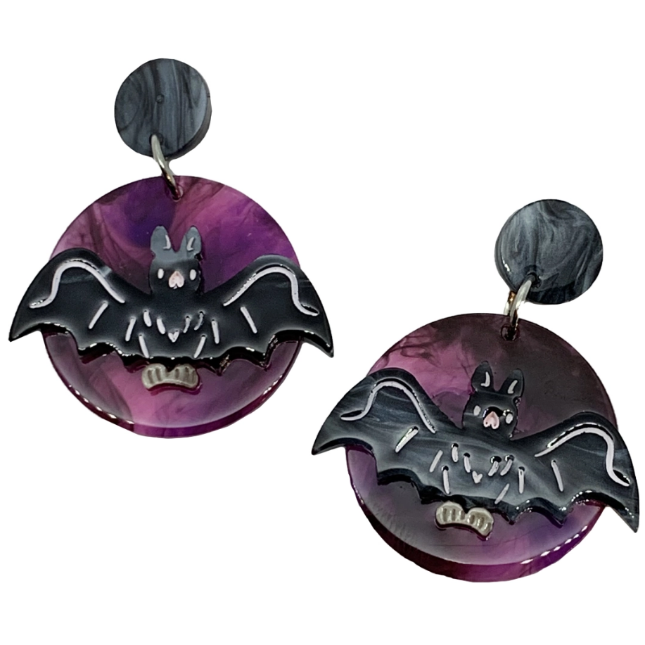 pair laser cut resin drop earrings feature a handpainted black bat against a circle of slightly translucent purple swirling sky with black resin disc ear post