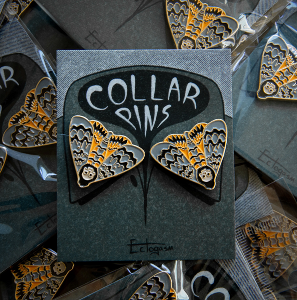 grey, golden yellow, and black enameled gold metal death's head moth clutch-back pin set to fit on collar points, shown on illustrated card backer packaging