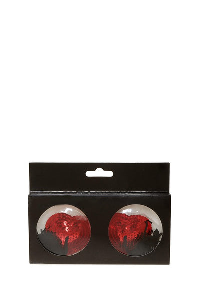 pair red sequin covered heart-shaped silicone pasties with black tassels, shown in windowed packaging