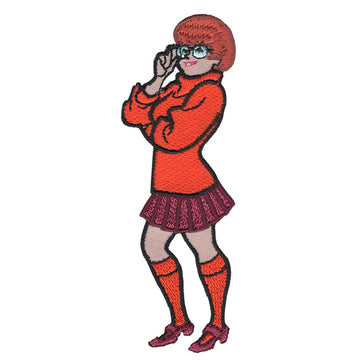 Scooby Doo cartoon character Velma Dinkley shown standing wearing orange sweater and knee socks and red pleated skirt embroidered patch