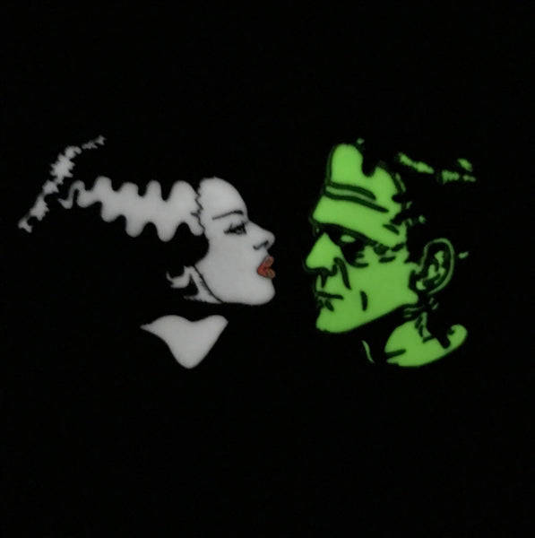 Glow-in-the-dark enamel pin set depicting the iconic "We Belong Dead" profile poses of Boris Karloff as the monster and Elsa Lanchester as his mate from the classic 1935 movie, Bride of Frankenstein