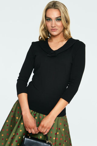 black stretch knit top with collared v-neckline with covered button detail, 3/4 length sleeves, fitted silhouette, and hip length. shown on model.