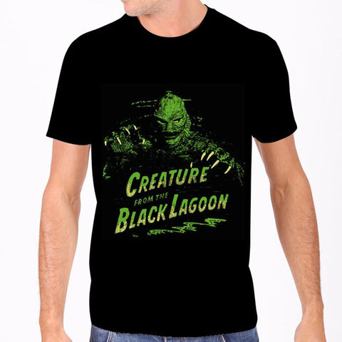 100% Cotton fitted black t-shirt featuring a vibrant green & yellow comic book style image of the Creature From The Black Lagoon coming at you behind the logo from the classic 1954 movie, shown on model