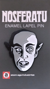 Face of Max Schreck as the vampire "Count Orlok" from the 1922 German Expressionist silent film, Nosfertu: A Symphony of Horror on a black, grey and white enameled lapel pin. shown on illustrated backer card packaging