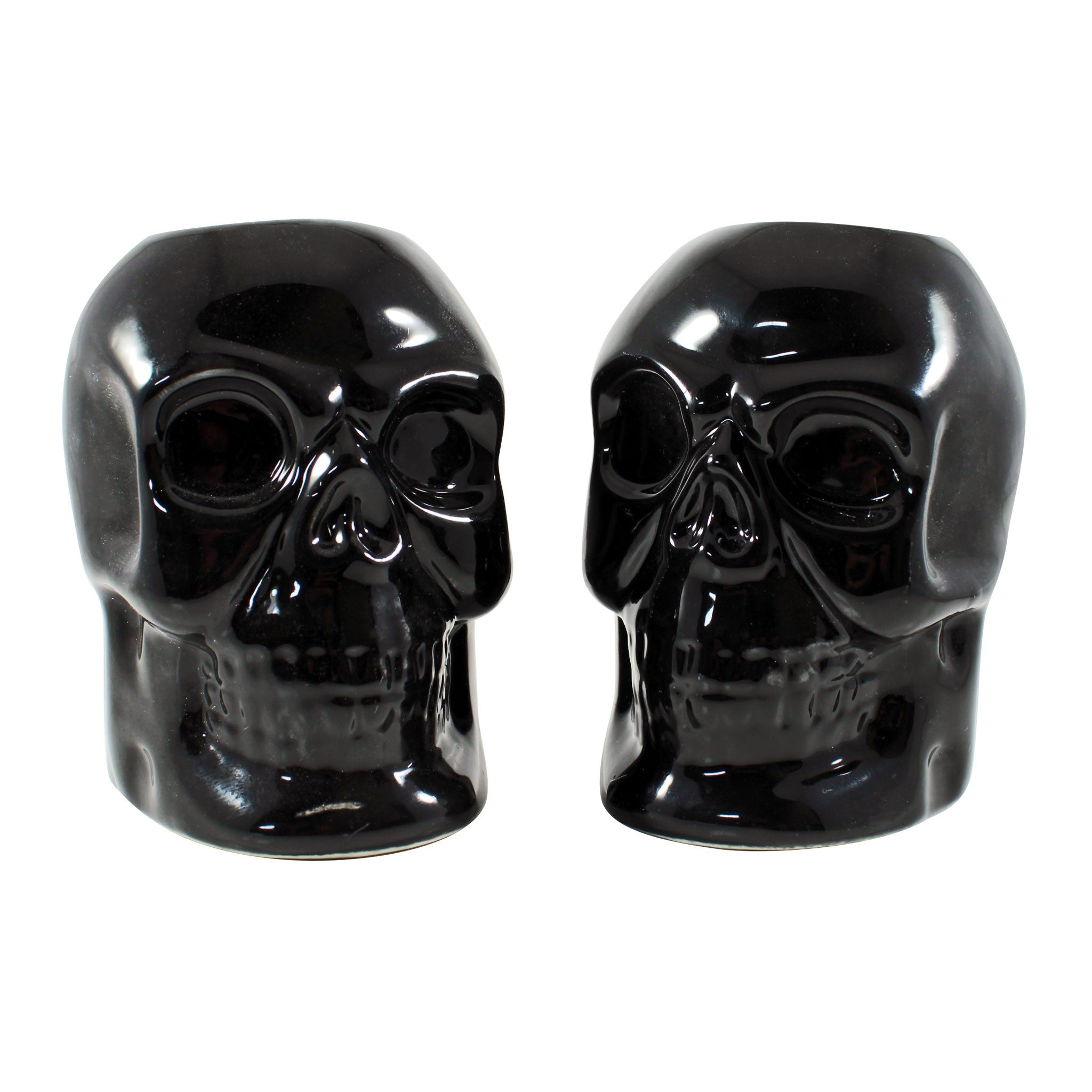 pair of porcelain skull shaped candleholders in black