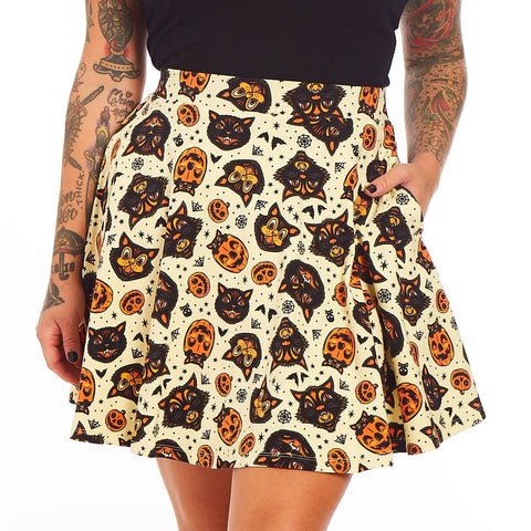 stretchy cotton knit "Classic Halloween" print cream background allover orange, black, and white cats, bats, jack-o'-lanterns, and spiderwebs print skater skirt, shown on model