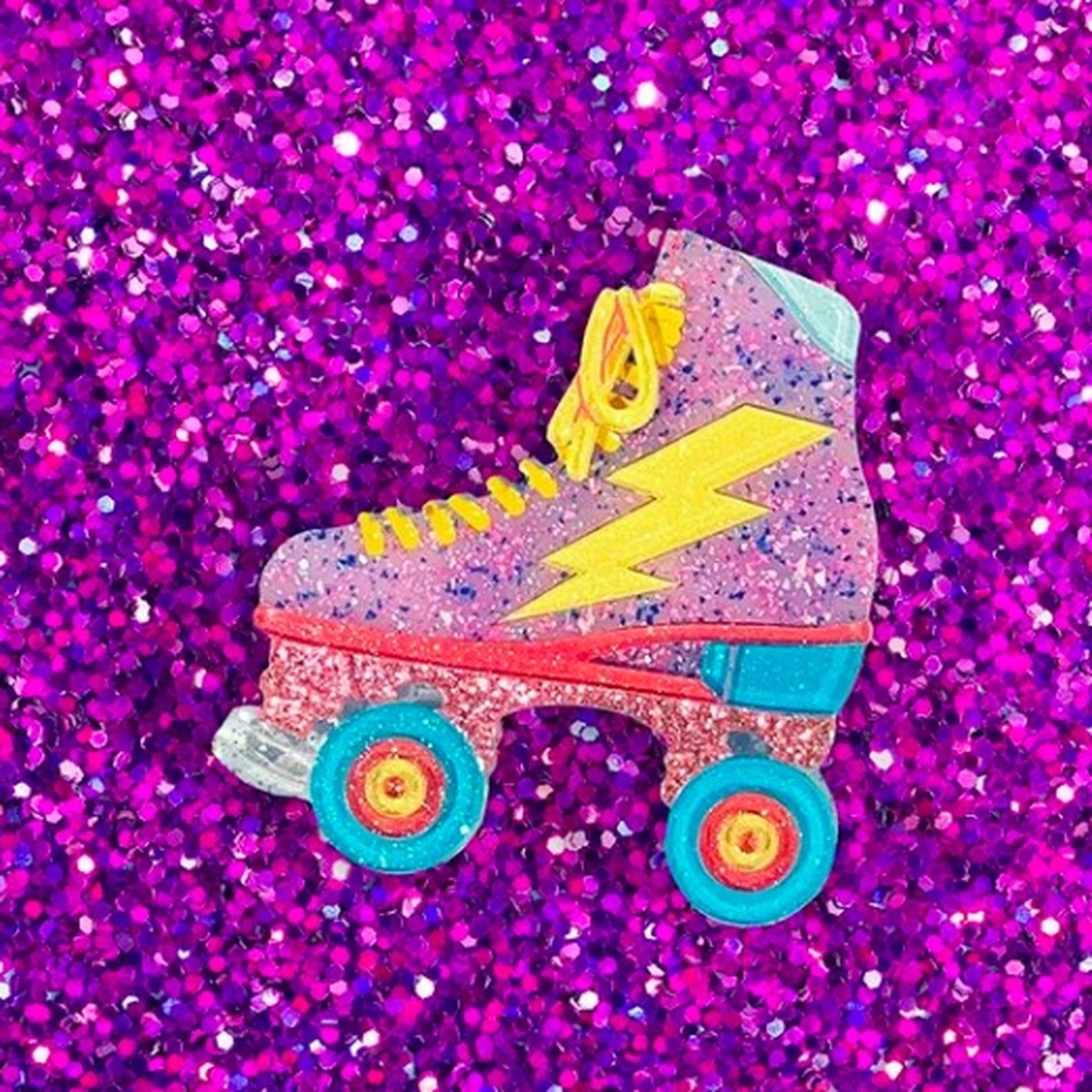 layered laser cut resin yellow lightning bolt decorated sparkly pink and aqua roller skate brooch