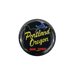 1.5" round metal pinback button featuring the iconic White Stag "Portland Oregon" neon sign against black background
