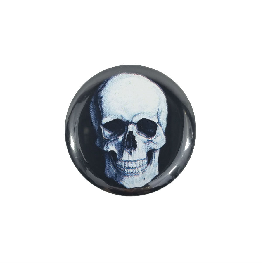 white anatomical skull against black background on a 1.5" round metal pinback button