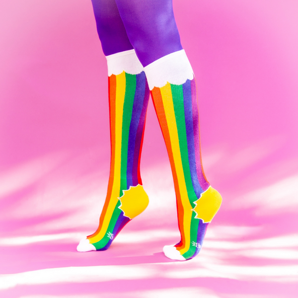 pair vertical rainbow stripes topped & toed by clouds with yellow sun heel soft stretch cotton blend knee socks, shown on model