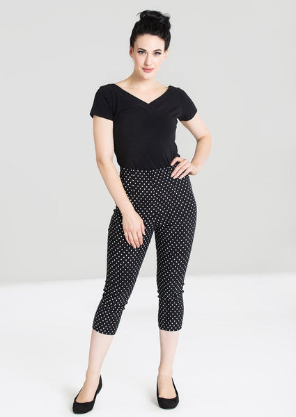 retro high waist fitted stretch capri length pants in black with white dot print, shown on model