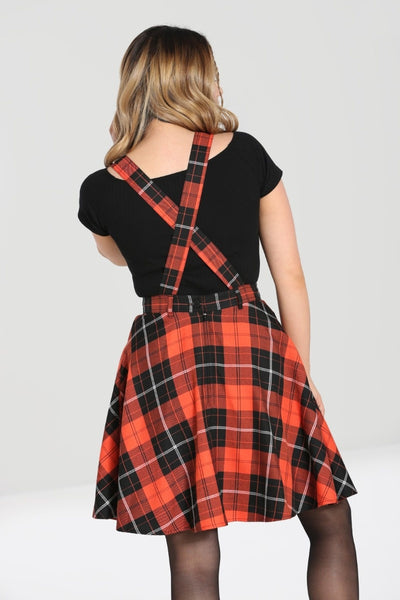 orange and black plaid pinafore dress with crossover straps, front button closure, nipped in waist, and flared above the knee length skirt, styled with black top, shown back view on model