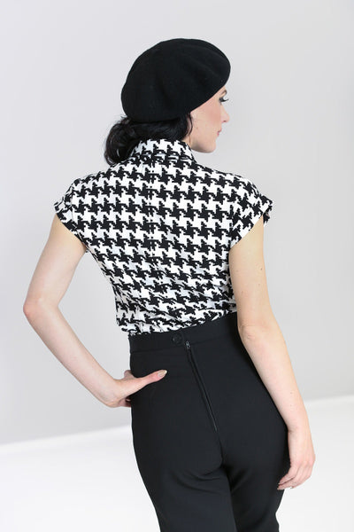 black and ivory houndstooth print short sleeve blose with black fabric tie at collar, shown back view on model