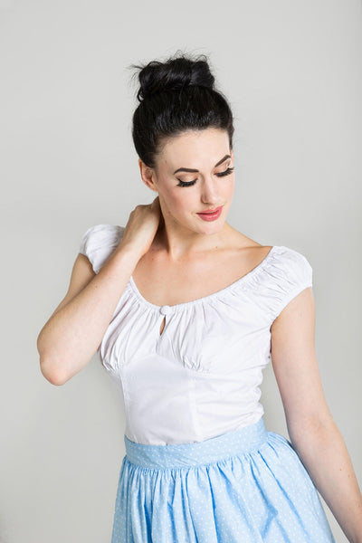retro style white stretch cotton peasant top featuring princess seamed bodice, cap sleeves, and peek-a-boo keyhole opening with button detail at the bust, shown on model
