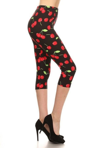 High-waist capri length leggings in black with allover red cherries print, shown on model