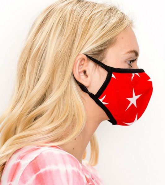 red with white star print knit face mask with black trim and ear loops, shown side view on model