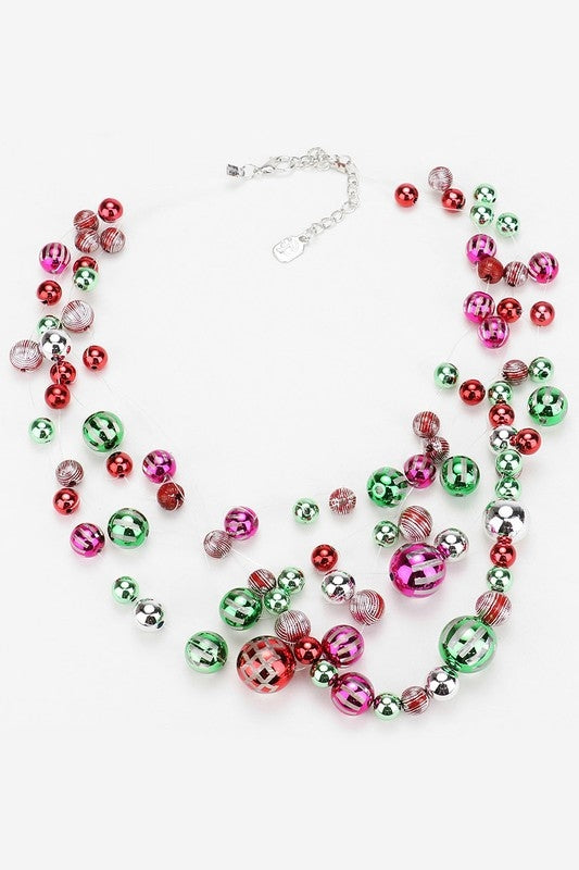 multi-strand necklace of metallic solid and decorated clear lucite beads that look just like vintage holiday ornaments, strung on clear filament